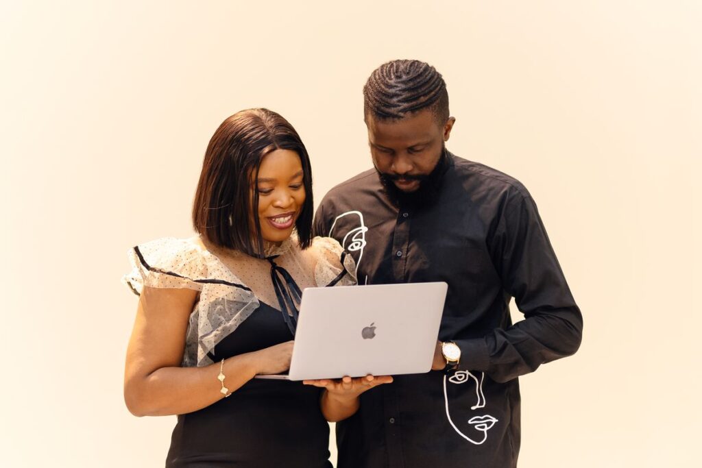 Two colleagues reviewing documents on a laptop in a Lagos office