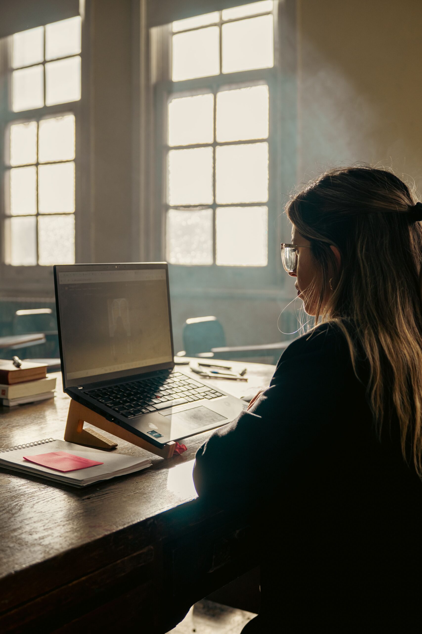 Student studying for Duolingo English Test on a laptop in a bright classroom
