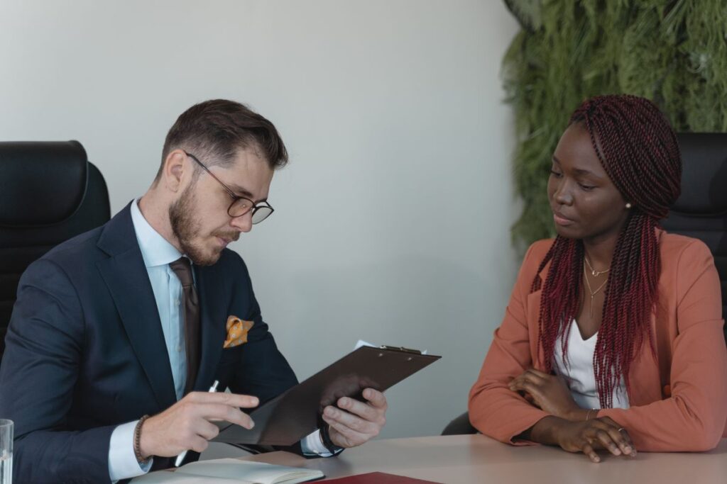 A candidate answering questions across a desk from an interviewer in a modern office