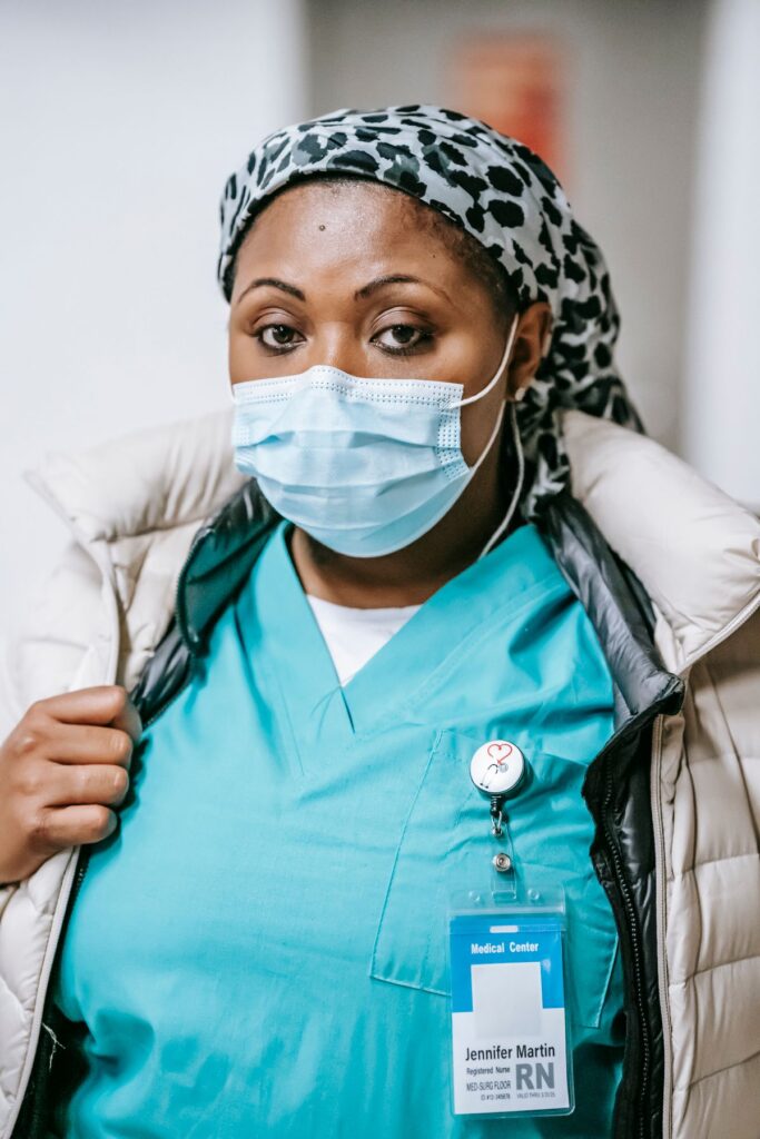 Nurse in blue uniform standing in a hospital corridor, the kind of role the UK Health and Care Worker visa still covers
