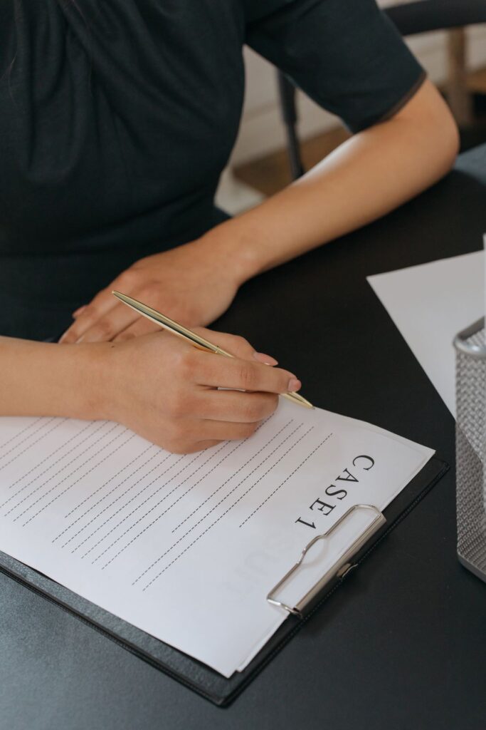 Person completing official academic documents by hand, part of the credential evaluation process