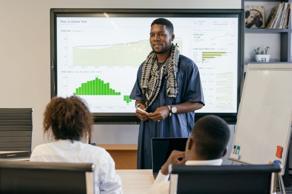 A man presenting project results to colleagues around a table in an office